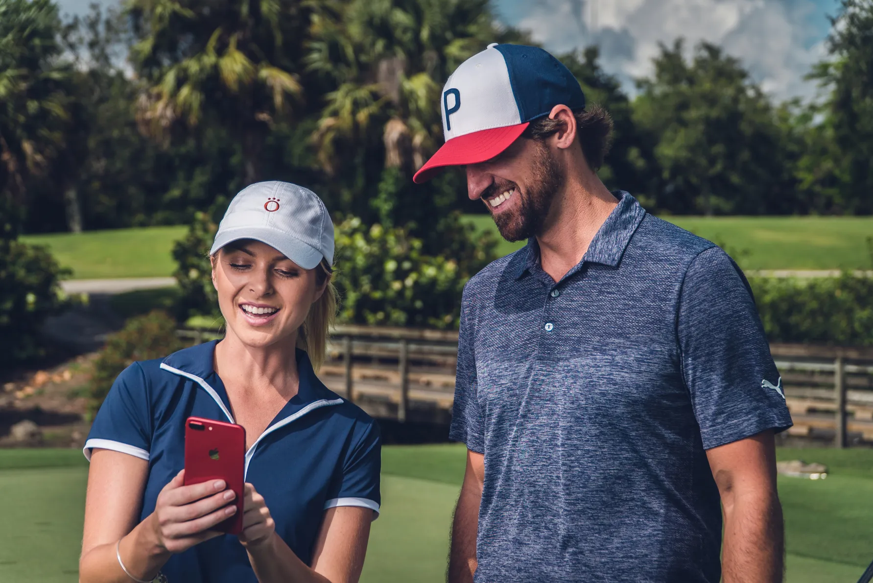 a man standing next to a woman holding a cell phone