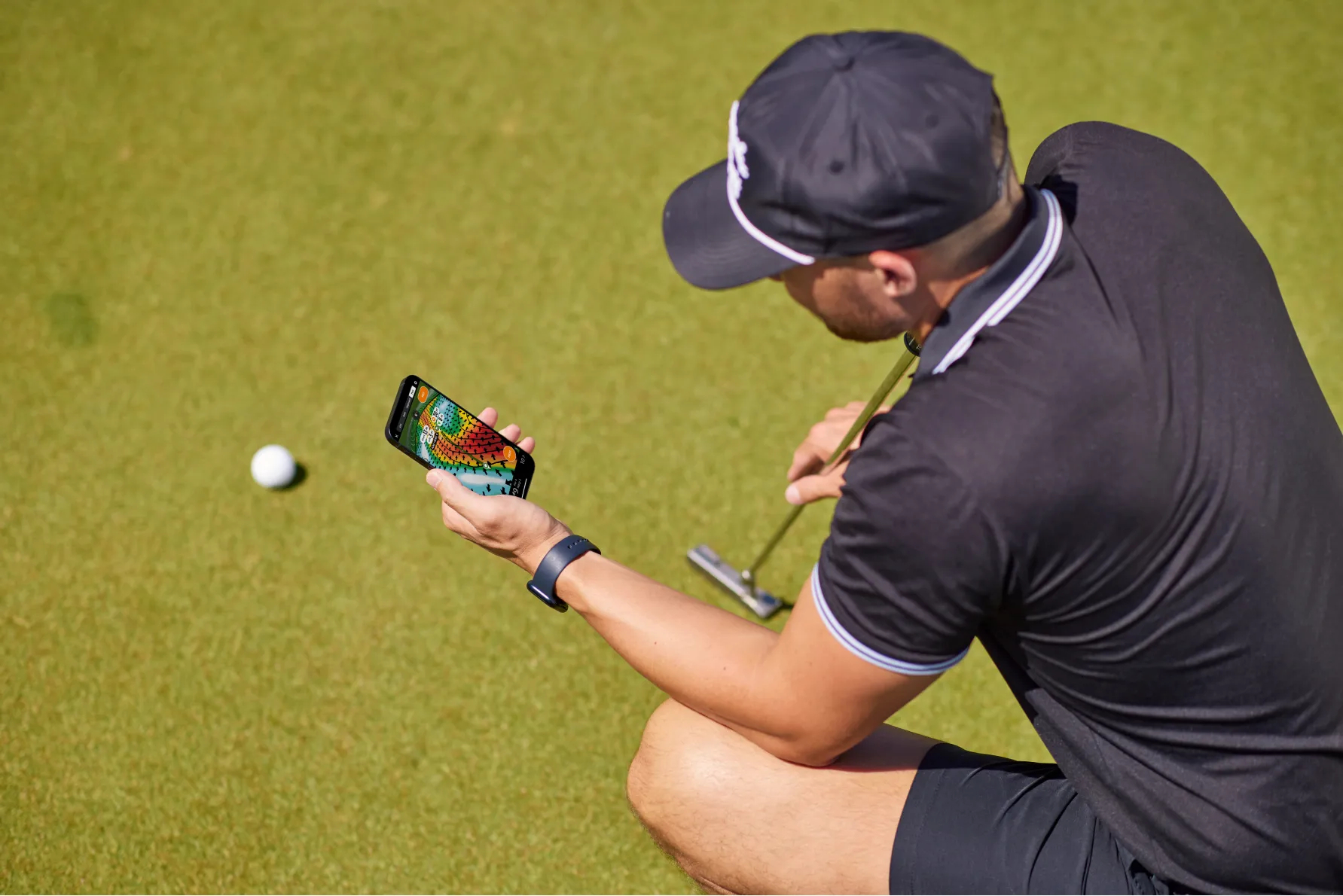 a man sitting on the ground playing a game of golf